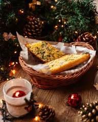 a straw basket with garlic bread garnished with herbs and cheese