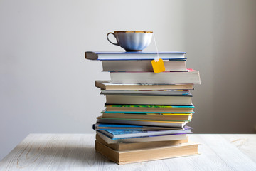 pile of books with a tea cup with a bag on top. Coronovirus Online Learning