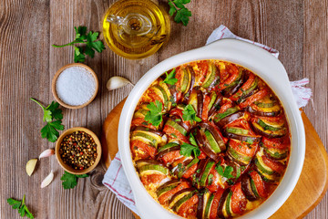 Cooked vegetable ratatouille with mozzarella cheese in white oven pan.