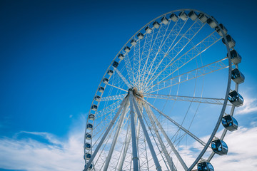 big ferris wheel in front of blue sky with clouds
