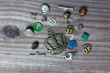 Buttons, sewing furniture, decorative elements on brown wooden background 