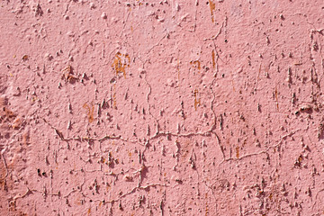 Pink old wall with cracks and smudges.