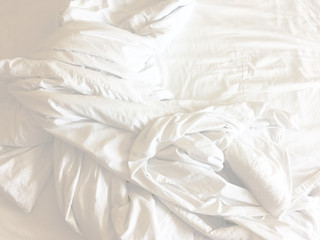wrinkle messy blanket in bedroom after waking up in the morning, from sleeping in a long night, details of duvet and blanket, an unmade bed in hotel bedroom with white blanket