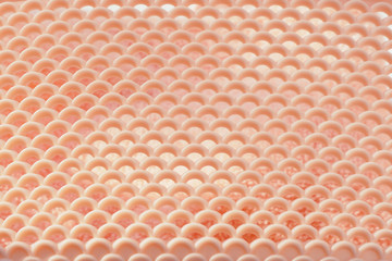 .Abstract background and texture pink plastic basket with triangular holes in bright sunlight. .