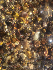 sea ​​pebbles in defocus blurred background of stones in water for design background
