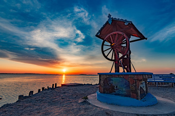 Beautiful landscape of a well with a wheel in the sunrise near the Razelm Lake, Razim, Sarichioi, Romania