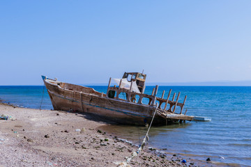 Tadjoura, Djibouti - November 09, 2019: Palms and Boats on the Sea Coastline under Blue sky