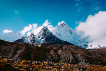 Snow covered beautiful mountain peaks and soft white clouds