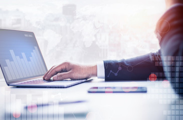 Businessman using laptop and smart phone  in office and city background and clipping path of laptop screen.Business, technology, internet and technology concept