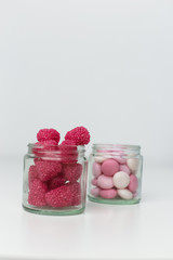 Obraz na płótnie Canvas raspberries in a jar and candy on the table