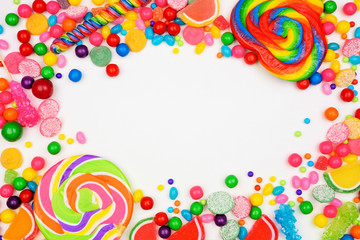 Colorful mixed candies. Top view frame over a white background.