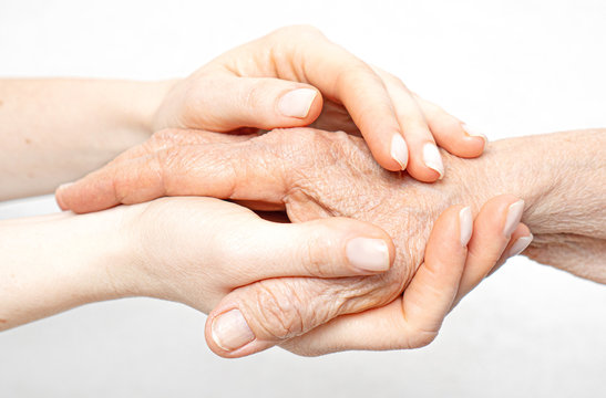 Helping hand for the elderly concept with young hands holding old hand.