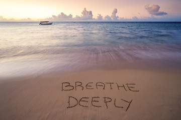Handwritten Breathe deeply on sandy beach at sunset,relax and summer concept,Dominican republic...