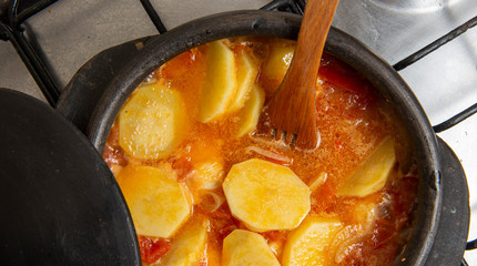 fish being cooked in a clay pot