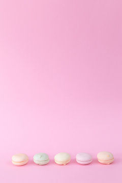 Delicate colored marshmallows on a pink background minimal style. Copy space