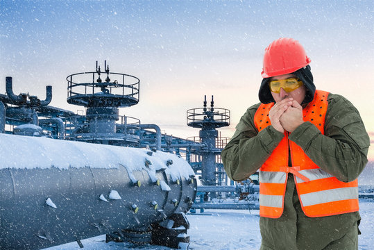 Worker At The Cold Oil Field , Natural Gas Storage In The Background.Refinery, Oil And Natural Gas, Wintertime