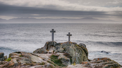 Two crosses on a rock at Cape Roncudo in La Coruña, Galicia, Spain.
