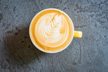 a cup of coffee on a dark blue floor 