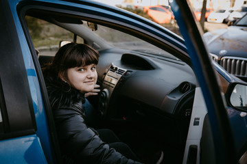 Fototapeta na wymiar Caucasian girl sitting in blue auto, travel