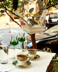 two cups of turkish coffee and two glass of green fizzy drink served at the restaurant garden