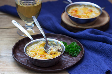 Julienne with mushrooms and bechamel sauce with cheese, served with white wine. Rustic style.