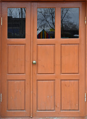 Brown wooden door. The texture of a double-leaf painted door with glass