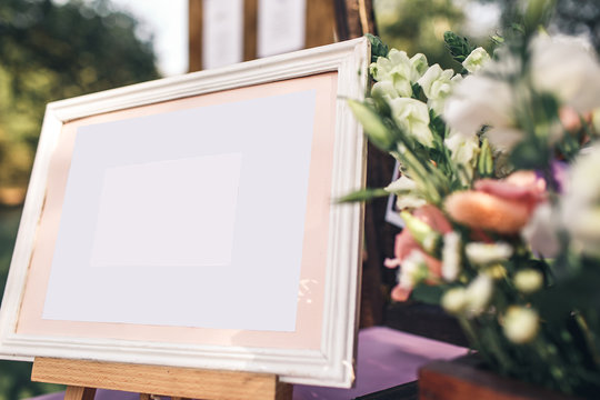 frame with canvas on an easel and flower decoration. copy space