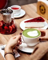 woman drinking a cup of matcha green tea with latte art