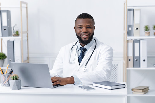 Photo of smiling african american doctor working in clinic