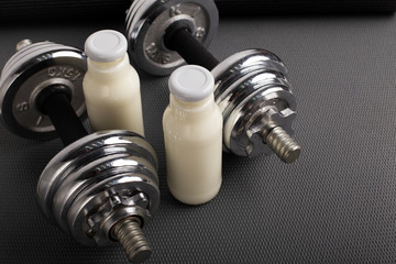 Protein drink with coconut milk and dumbbells for sport