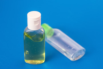 Antiseptic for hands, one full bottle and one empty. On a blue background