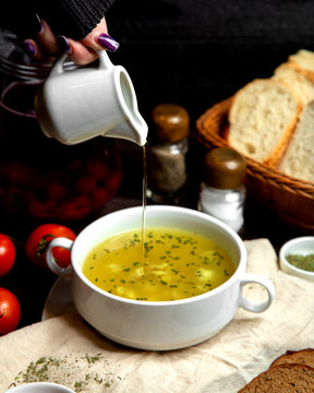 woman pouring vinegar into dushbara dumpling soup