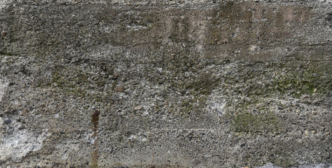 An old concrete surface with traces of destruction exposed stones interspersed