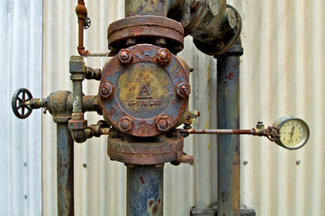 Old rusted industrial valve and pressure guage from bygone era 