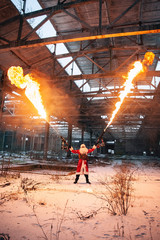 Santa Claus with flamethrowers in an abandoned warehouse