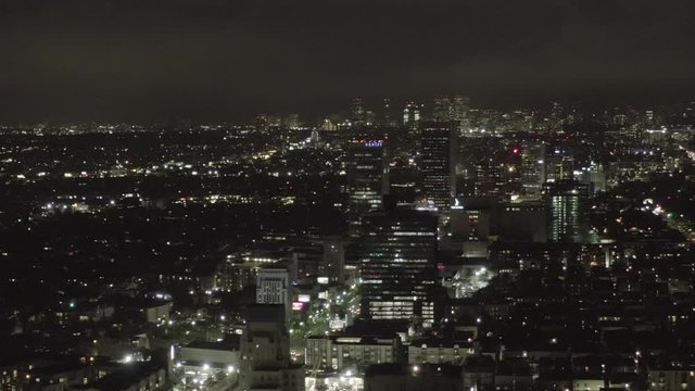 AERIAL: Over Dark Hollywood Los Angeles at Night with view on Skyline and City Lights 
