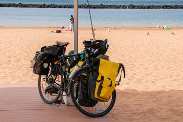 Obraz premium tourist bike with bags on the beach background, concept of cycling tourism