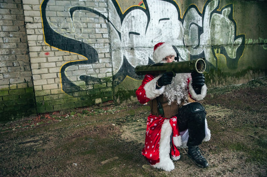 Santa Claus with a grenade launcher in an abandoned warehouse