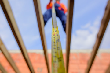 Builder equipment. Measuring device. Selective focus. Builder with tape measure. Construction worker on construction site with roulette. Roofer carpenter in helmet with meter. Worker use tape measure.