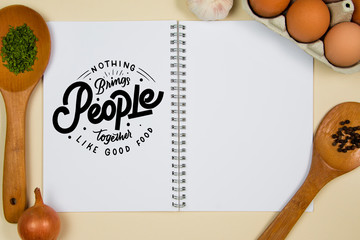 Wooden ladles with spices, eggs and garlic with a blank notebook page