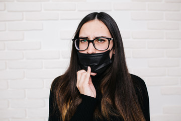 brunette girl in glasses for vision correction is protected from a viral infection: coronavirus. A...