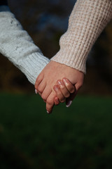 Hand of two girls.  Sisters on a background of green grass