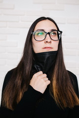 brunette girl in glasses for vision correction is protected from a viral infection: coronavirus. A...