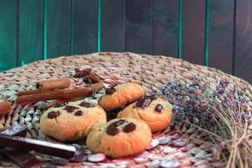 Cookies with chocolate, on a woven backing, on a background of dark boards. Dark turquoise boards of the table.