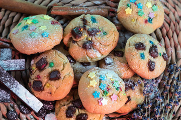 Homemade cookies with chocolate. Still life of cookies on a wicker stand. Cinnamon, chocolate, and a sprig of lavender.