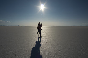 Silhouette and shadow of a happy, adventurous couple doing a piggyback ride