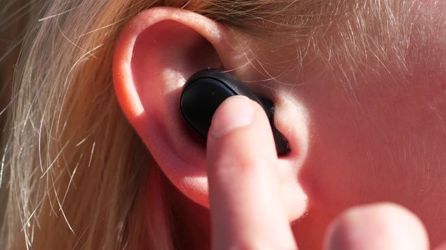 Woman Turning Up the Volume on Her True Wireless Earphones