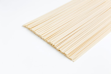 Raw udon noodles on white, horizontal photo