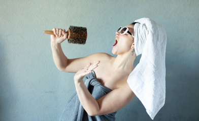 girl sings in a comb on her head wound a white towel