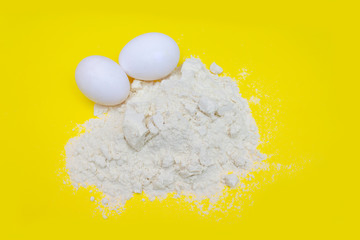 Pile of banana protein powder and eggs isolated on yellow background
